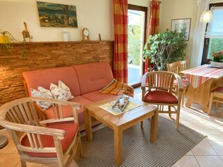 Wohnzimmer mit Esstisch und Zugang zu Terrasse / Garten