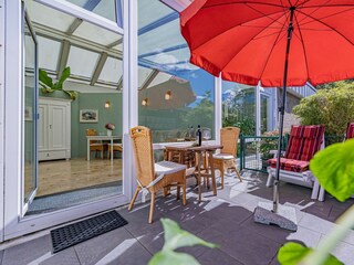 Sonnige Terrasse mit Gartenmöbeln und Sonnenliegen
