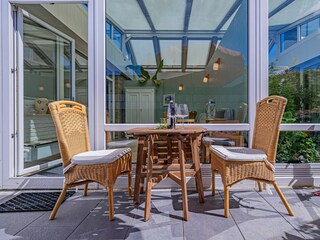 Sonnige Terrasse mit Gartenmöbeln und Sonnenliegen