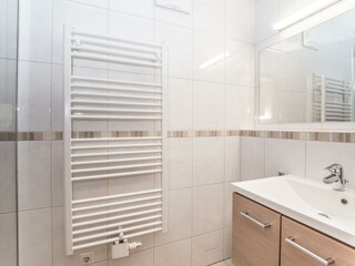 Kleines Badezimmer mit Dusche und Waschtisch.