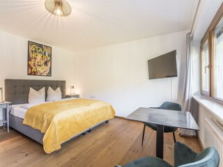 Geräumiges Schlafzimmer mit Tisch und Stühlen.