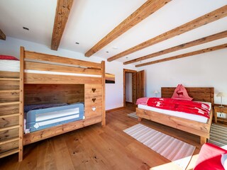 Schlafzimmer mit Doppelbett und großem Stockbett