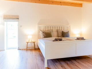 Schlafzimmer mit Doppelbett (180x200cm) und Gartenblick