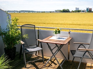 Balkon mit einem Tisch, Stühlen und einer Sonnenliege