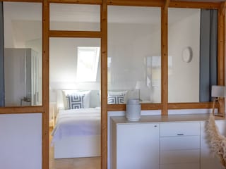 Schlafzimmer hinter verglaster Fachwerkwand