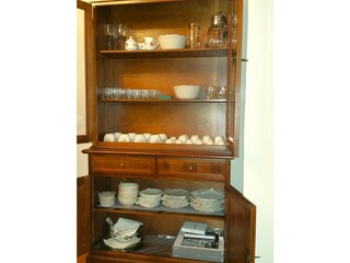 Dining room cupboard, with sets of dishes, glasses etc.
