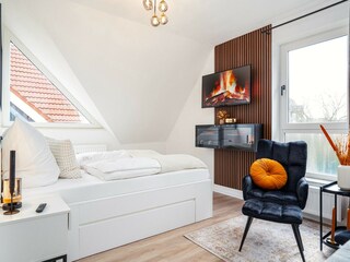 Gemütlicher und heller Schlafbereich mit TV
