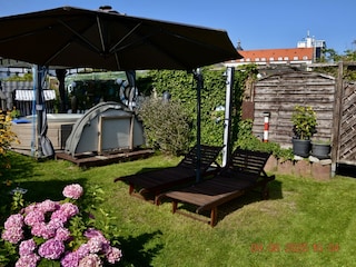 Liegewiese mit Sonnenschirm und Außendusche