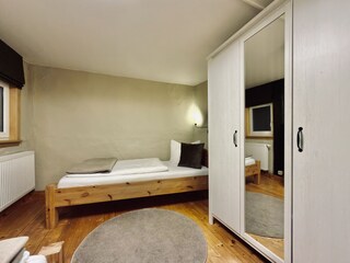 Schlafzimmer im OG mit Einzelbett und Kleiderschrank
