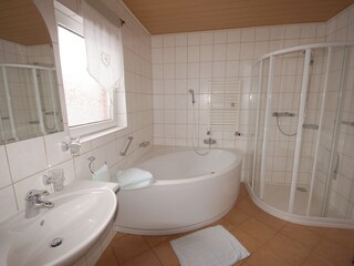 Bathroom with corner bathtub and big shower