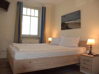 Schlafzimmer mit Doppelbett + TV