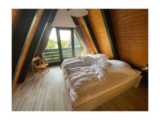 Schlafzimmer mit Doppelbett und Balkon OG