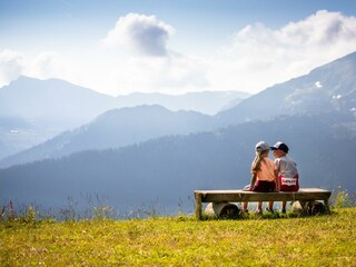 Kinder-sitzen-auf-Rastbank-Alpbach-Wiedersbergerho