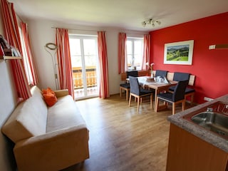 Helle Wohnküche mit Küchenzeile, Essecke und Couch