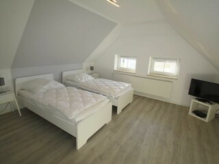 Schlafraum mit 2 Einzelbetten + TV im Obergeschoß. Bild 2