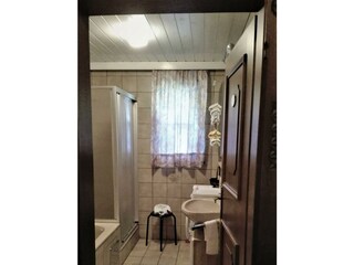 Badezimmer mit Badewanne und Waschmaschine