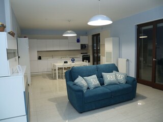 Wohnzimmer mit Sofa und Küche