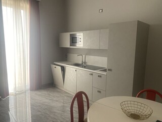 Küche mit Kühlschrank, Backofen, Waschmaschine und Gesc