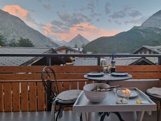 Aussicht vom Balkon mit Tischchen und drei Stühlen