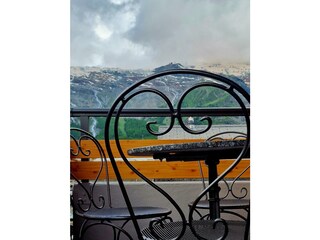 Tischchen auf dem Balkon mit Schmeideisenstuhl