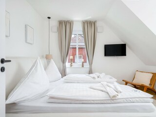 zweites Schlafzimmer mit Doppelbett und TV
