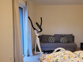 Schlafzimmer mit Hometrainer und Sofa