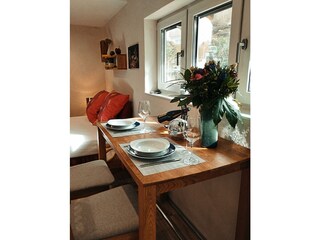 Blick über den Esstisch zum Bett