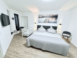 1. Schlafzimmer mit TV und optional Babybett