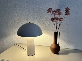 Nachttisch mit Lampe und Blumendekoration
