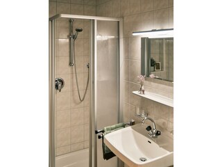 Dusche mit Waschbecken und Spiegel