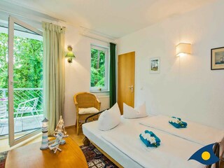 Wohnzimmer mit Schlafcouch und Zugang zum Balkon