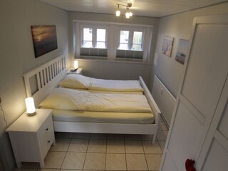Schlafzimmer mit Doppelbett und Schrank.