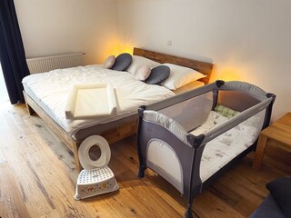 Schlafzimmer mit Babybett und Babyausstattung