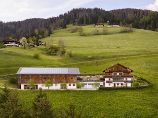 Der Hof umgeben von grünen Wiesen