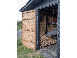 Garage mit Brennholz, alten Fahrrädern und Paddelbooten