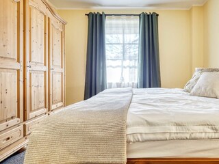 Schlafzimmer mit Doppelbett und Kleiderschrank