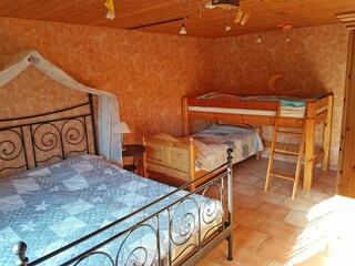 Schlafraum mit Doppelbett, Hochbett und Einzelbett
