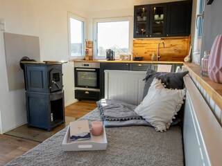 Wohnbereich mit Sofa, Kamin und Küchenzeile