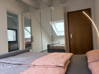 Schlafzimmer mit Spiegelschrank und Blick zum Wohnzimme