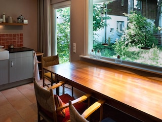 Küche mit großem Esstisch und Tür in den Garten.