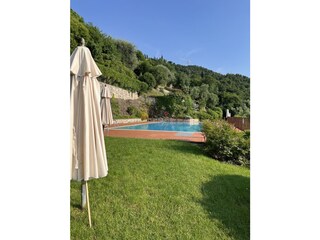 Liegeweise am Pool mit Sonnenschirm