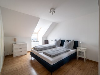 Schlafzimmer mit Doppelbett, Kommode und Kleiderschrank