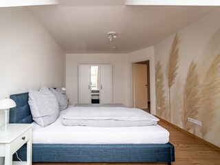 Schlafzimmer mit Doppelbett, Kommode und Kleiderschrank