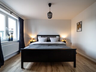 Schlafzimmer 1 mit Doppelbett und begehbarer Ankleide