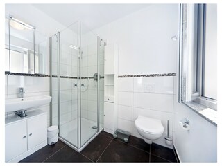 Das 1. Bad mit Dusche, WC und Fenster.
