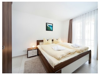1. Schlafzmmer mit Doppelbett, Kleiderschrank und TV.