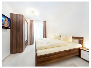 2. Schlafzimmer mit Doppelbett, Kleiderschrank und TV.