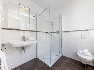 Das Bad zu Schlafzimmer 1 mit Dusche, WC, Fön, Fenster.