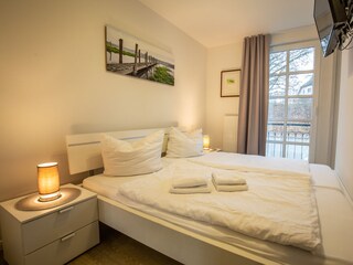 Schlafzimmer mit großem Doppelbett und TV