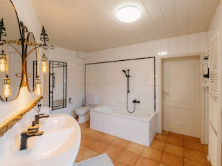 Großes Badezimmer mit Badewanne und Dusche